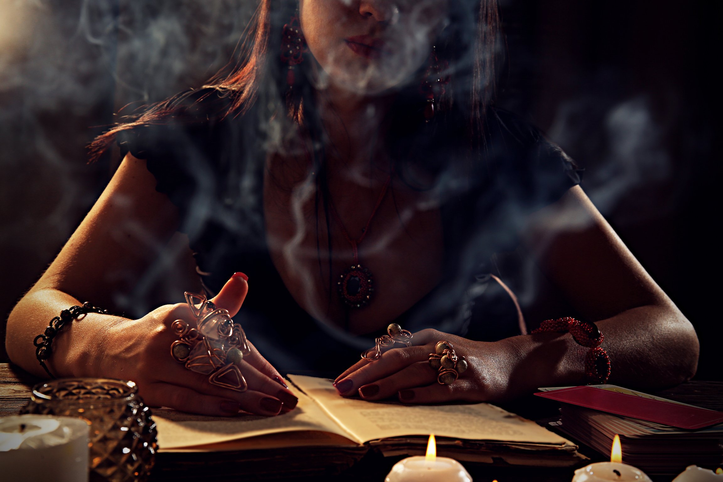 Woman Reading a Book at a Table Surrounded by Smoke